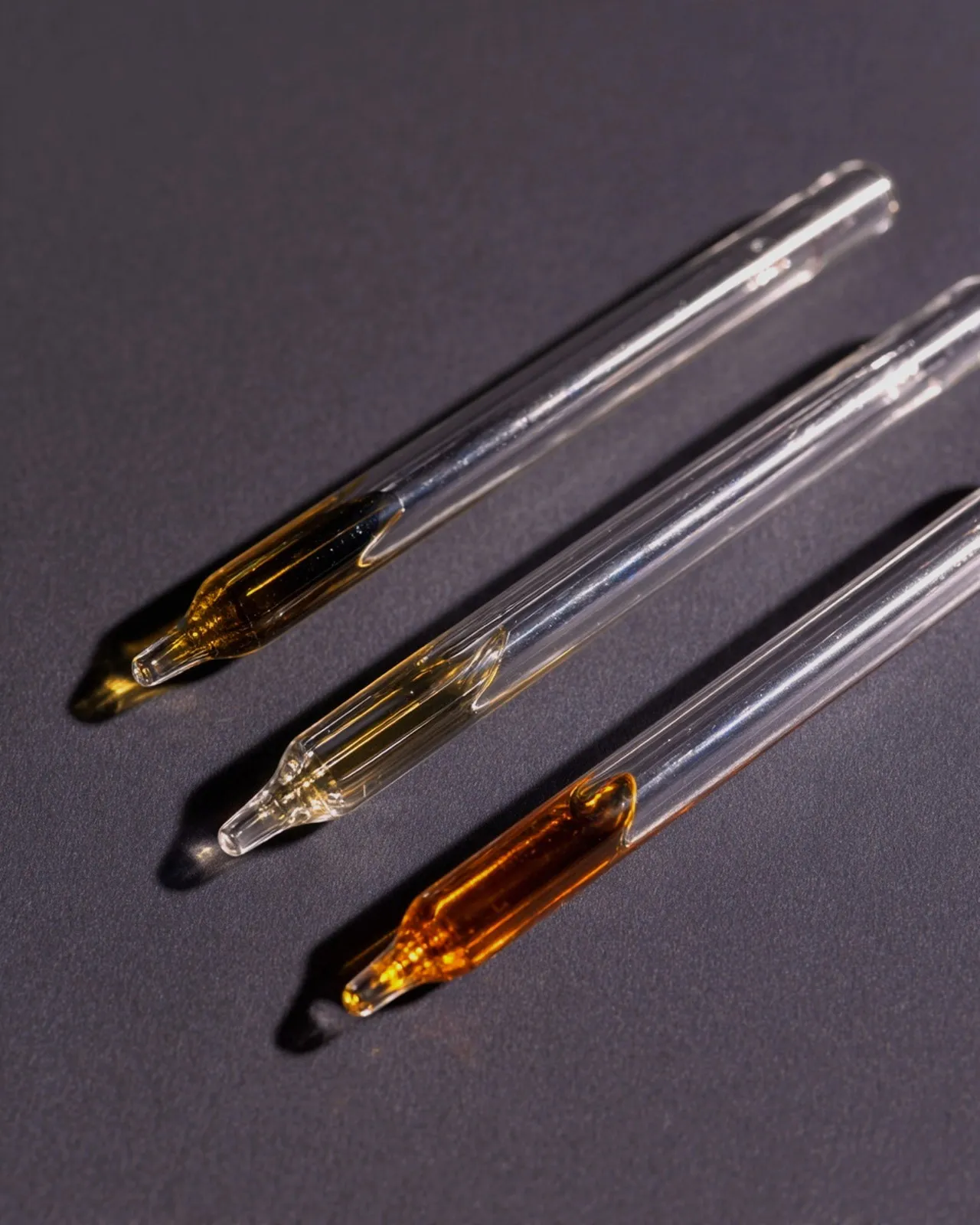 Glass pipettes holding amber perfume materials